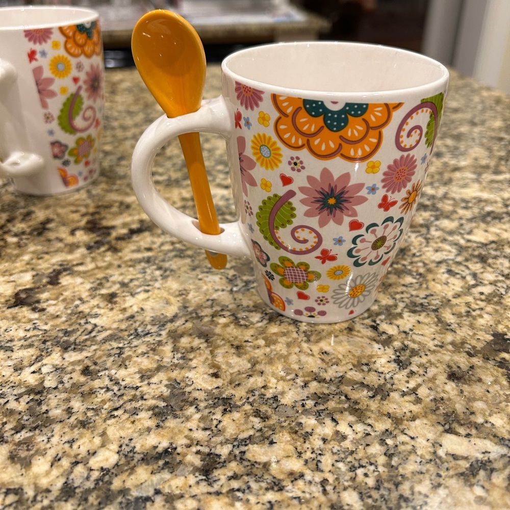 Floral coffee mugs with ceramic spoon and slot in handle for spoon.